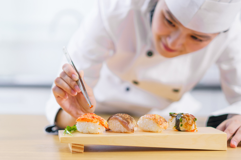 The female chef making the sushi dish